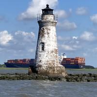 Cockspur Island Lighthouse with container ship passing by