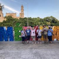 Sarah, Yvette, Marjie, Janet, Richard and Airdrie in front of Merida sign
