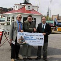 George Layfield, Chief of Staff of the Injured Worker’s Insurance Fund (IWIF) presents a check for $10,000 to Henry Gonzalez, U.S. Lighthouse Society, and Buck Buchanan, Annapolis Maritime Museum. IWIF is the first corporate sponsor for the lighthouse partnership.